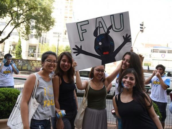 Meninas levantam a placa com o nome da Faculdade de Arquitetura da USP (Foto: Fabio Tito/ G1)